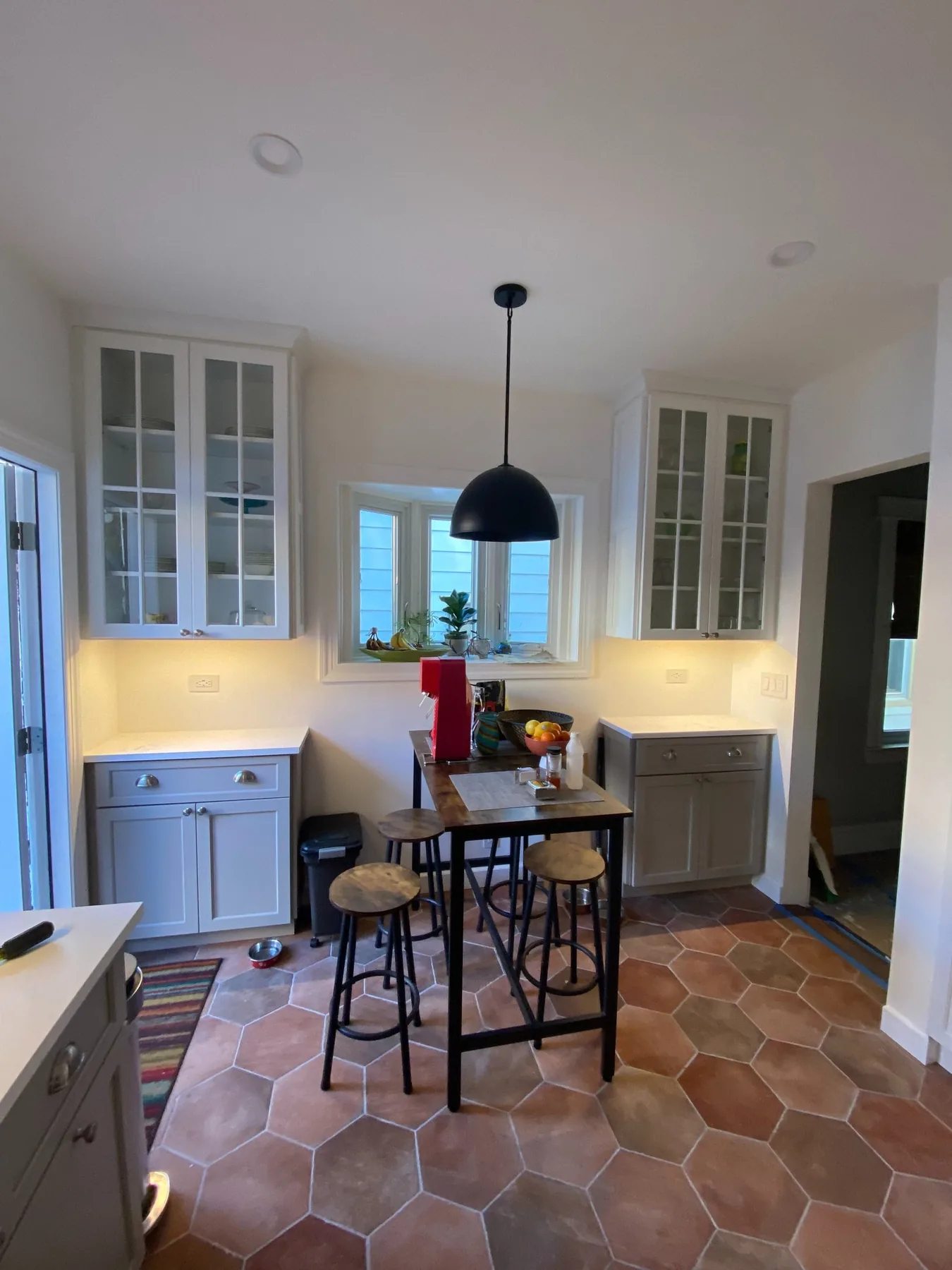 A breakfast nook with a pendant light and under-cabinet lighting
