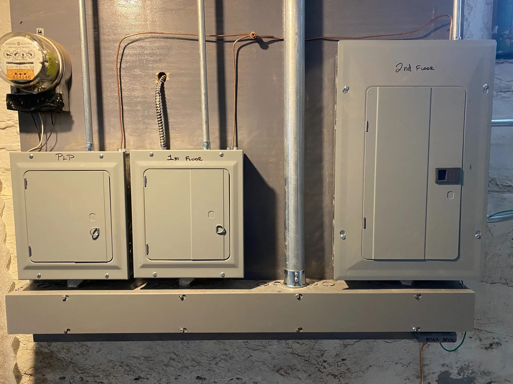 Meters and disconnect enclosures mounted on an exterior masonry wall