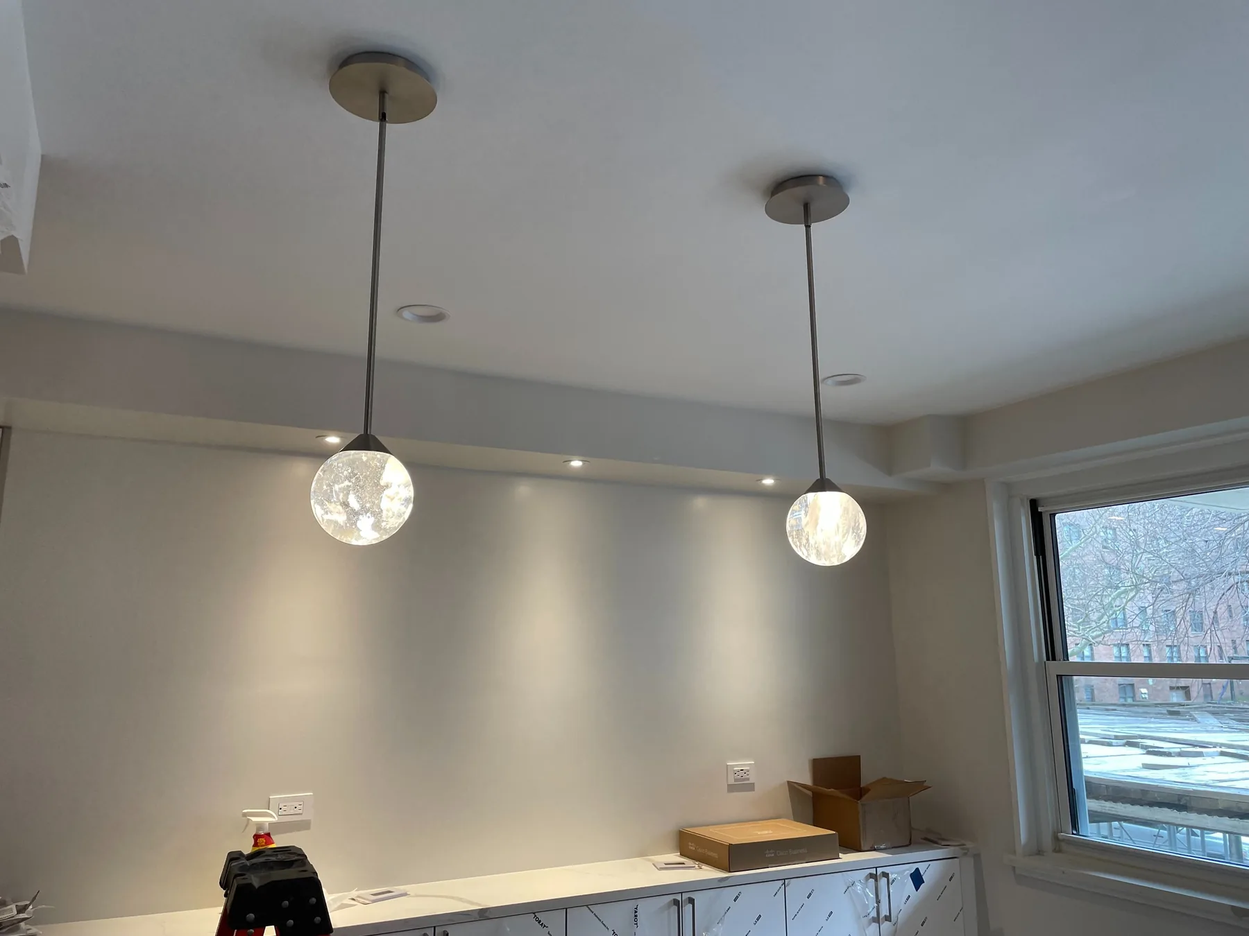 Two glass pendant lights hung from a ceiling