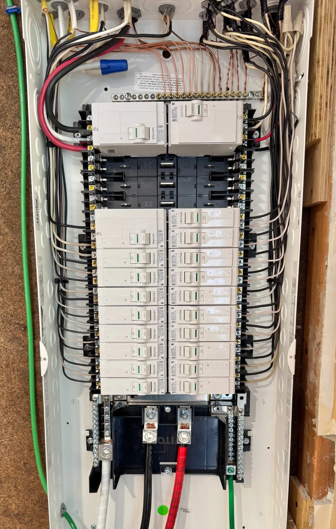An open electrical panel with breakers installed and conductors neatly dressed